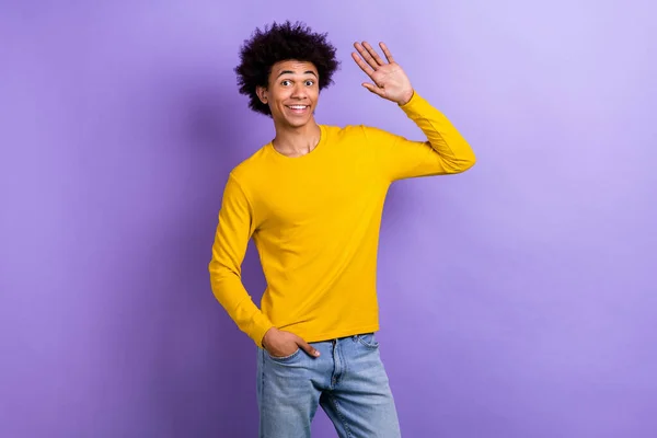Portrait of satisfied funky young person arm palm waving hello have good mood isolated on purple color background.