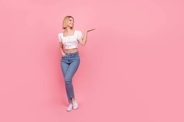 フルサイズ写真のかなり若い女性プロモーターホールドオープンヤシの美しさ製品着用シャツジーンズシューズ孤立ピンク色背景 — ストック写真