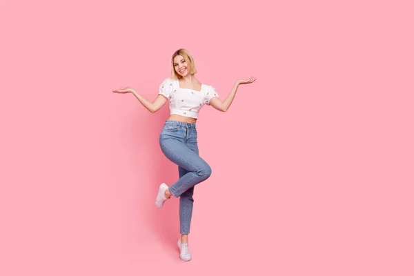 若い面白い女性の完全な長さの幹部は 白い作物のトップシャツを着用手のバランスは ピンクの色の背景に隔離された選択肢を選択 — ストック写真
