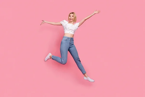 魅力的な女の子ジャンプ精力的に楽しい手を持っていますアップ実行大販売モデルプロモーターピンク色の背景に隔離 — ストック写真