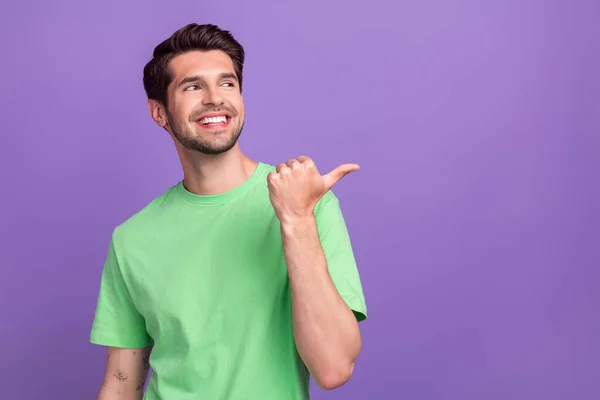 초록색 티셔츠를 긍정적 남자의 사진은 보라색 배경에 고립된 공간을 홍보하는 — 스톡 사진