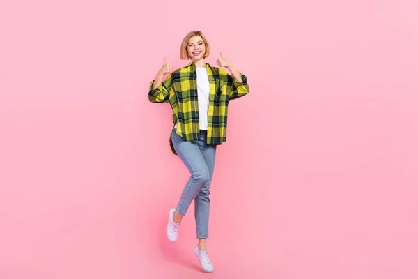 フル長さ写真の魅力的な若い女性ショーダブル親指アップ服スタイリッシュなチェッカー付き黄色の衣装隔離されたピンク色の背景 — ストック写真