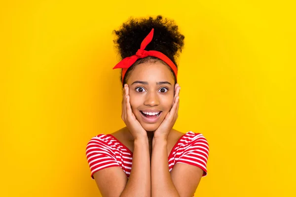 Photo of sweet excited lady wear striped red t-shirt smiling arms cheeks isolated yellow color background.