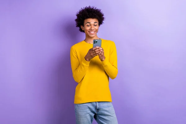 一个积极向上的正派年轻人的肖像用智能手机聊天 用紫色背景隔离发短信 — 图库照片