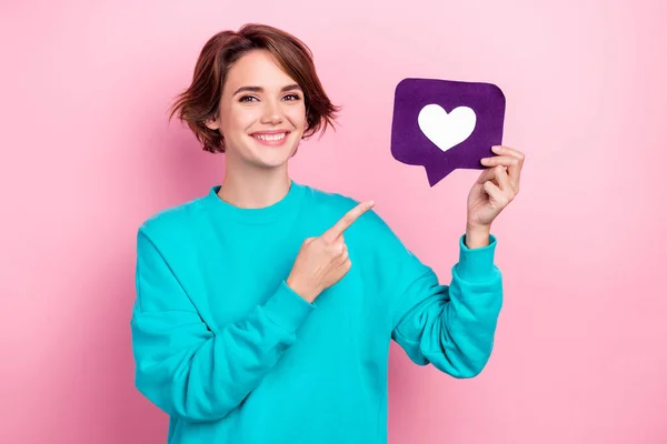 stock image Photo of cheerful lovely person toothy smile indicate finger hand hold paper like notification card isolated on pink color background.