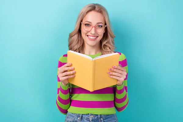 心满意足的漂亮姑娘的画像 留着波浪般的发型 头戴时髦的衣服眼镜 带着一本蓝色背景的书 — 图库照片