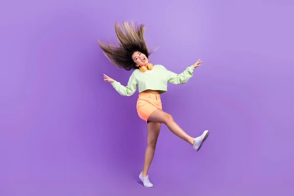 女孩气色好 女人穿着绿色衬衫 嬉皮笑脸 跳跃的全长照片 有紫色背景的独立乐趣 — 图库照片