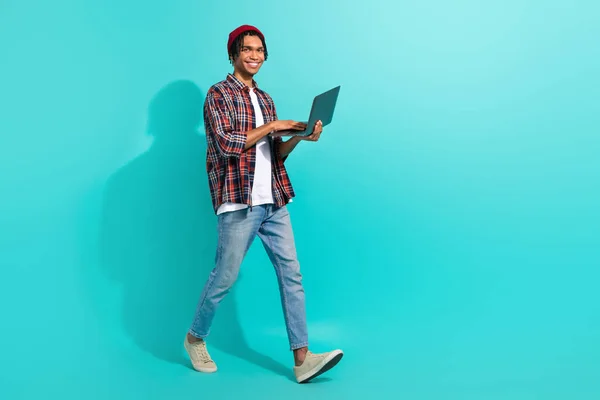 フルボディプロフィール写真のハンサムな男歩くホールド使用Netbook空のスペース広告孤立した上のティール色背景 — ストック写真