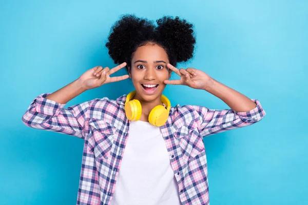 stock image Photo of sweet excited lady wear plaid shirt earphones showing two v-signs cover eyes isolated blue color background.