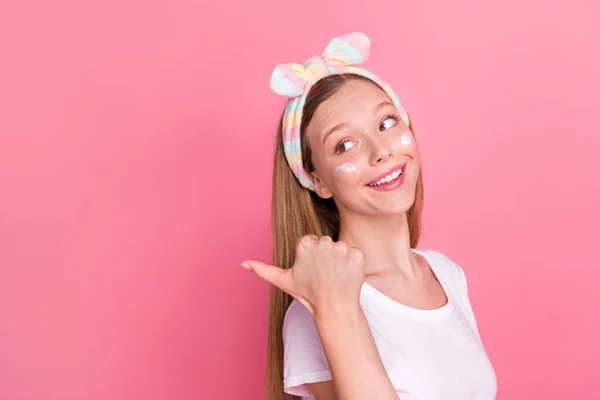 素敵な十代の女の子のプロフィール肖像画は ピンクの色の背景に隔離された目の下に直接親指指空のスペースの顔のクリーム — ストック写真
