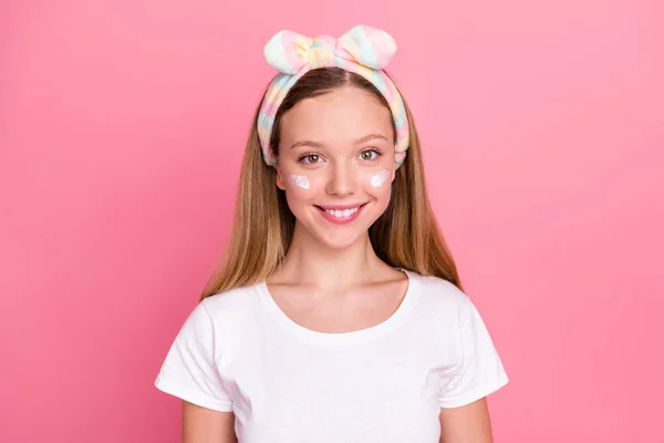明るい女の子の写真歯の笑顔適用顔クリーム頬はピンクの色の背景に隔離された白いTシャツを身に着けています — ストック写真