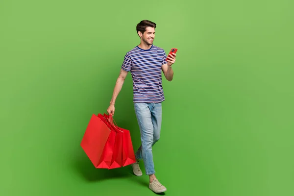 全长照片 照片上穿着条纹T恤衫的男子在网上购物 现代装置孤立的绿色背景 — 图库照片