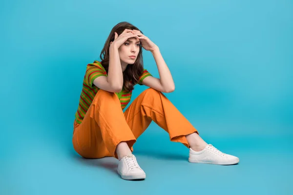 stock image Full length photo of minded ponder pensive girl wear striped shirt arms on forehead look empty space isolated on blue color background.