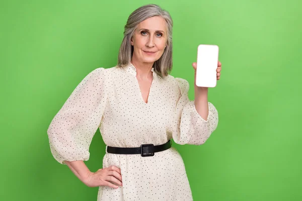 stock image Photo of shiny cheerful woman dressed beige outfit holding apple samsung iphone device empty space isolated green color background.