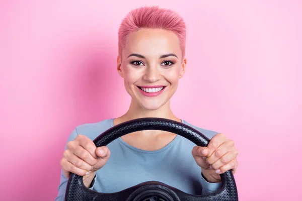 粉红背景下 驾驶学校时 穿着时髦衣服的乐观女性手持方向盘的画像 — 图库照片