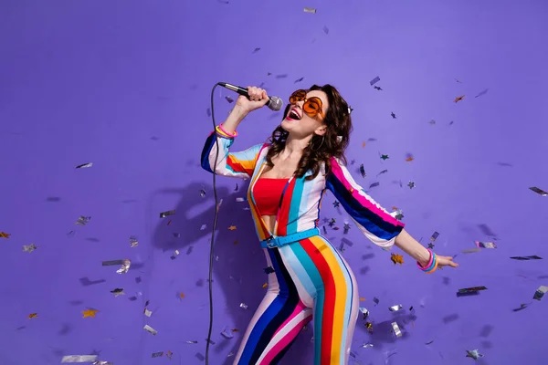 照片上的美女穿着条纹的深色眼镜 唱着迪斯科舞厅的歌曲 背景是紫色的 — 图库照片