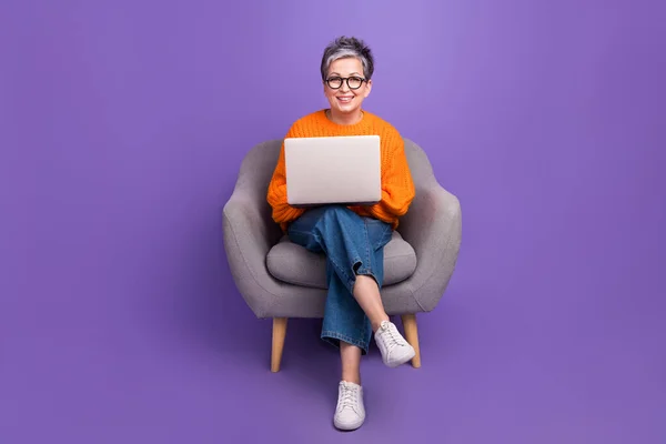 坐在舒适的椅子上 高级经理 程序员 女商人 年事已高 背景是紫色的 — 图库照片