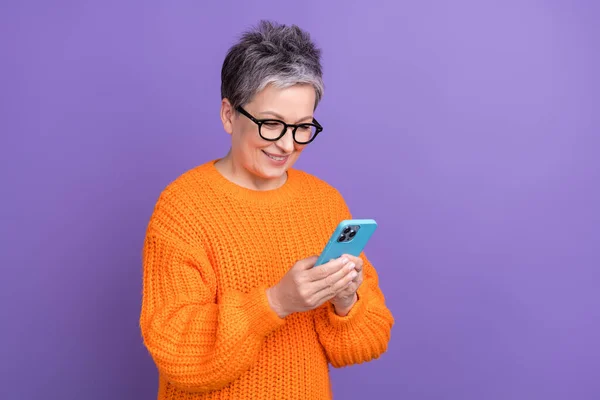 用紫色背景隔离的智能手机写电子邮件 刻画白发苍苍 头戴针织毛衣的人的形象 — 图库照片