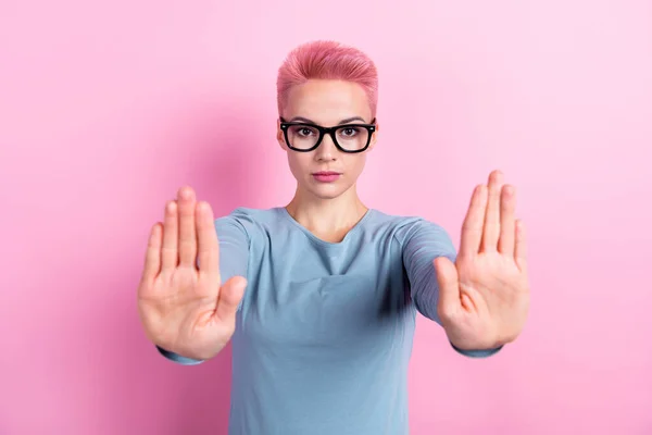 真剣な自信を持った女性の肖像画 青いスタイリッシュな服の腕の手のひらはあなたがピンク色の背景で隔離されたジェスチャーを停止することを示しています — ストック写真