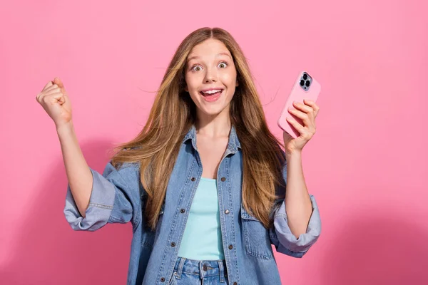 陽気で幸せな少女の肖像画は スタイリッシュなデニム服を着用し 販売割引デバイスショップを祝います ピンク色の背景で隔離されています — ストック写真