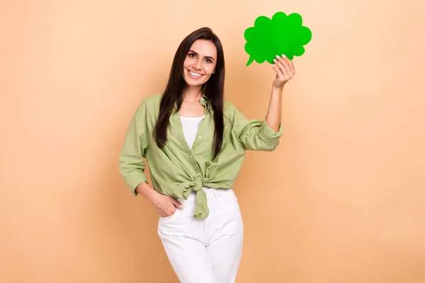 乐观快乐可爱的女人穿着绿色衬衫手拿着绿色泡泡云彩隔离在米色背景下的画像 — 图库照片