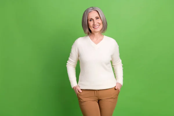 フォーブス誌のためにポーズをとる中年退職女性のハンドポケットの写真 緑色の背景で隔離された最高のビジネスコーチ — ストック写真