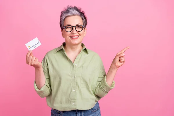成熟的女商人拿着借记卡取款的照片 直接用手指模仿粉色背景 — 图库照片