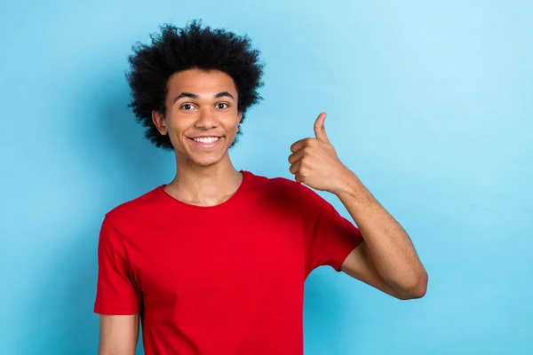 興奮する多民族カーリーヘア青年男の肖像画は 赤いTシャツを隔離された青い色の背景を身に着けている親指を上げます — ストック写真