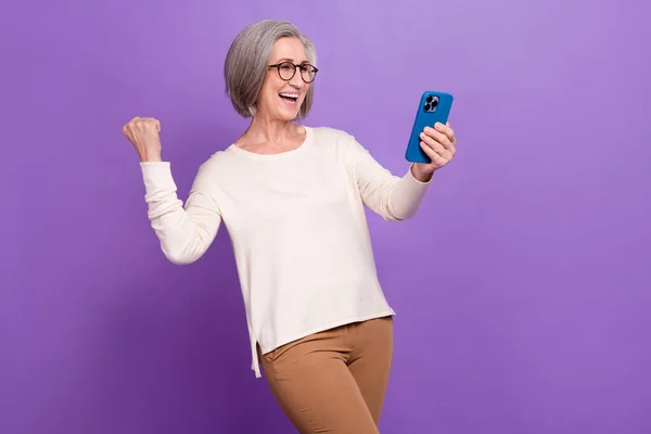 stock image Photo of excited business lady fist up achieve successfully got her smartphone latest model best options isolated on purple color background.