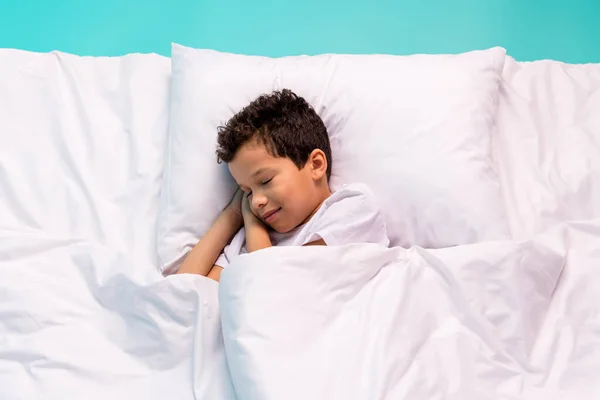 上の景色 平和な学校の子供の肖像画 寝る快適なベッドシーツ枕はターコイズの背景で隔離された毛布を覆いました — ストック写真