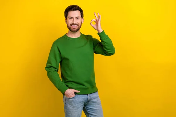 楽観的な若いビジネスマンの推奨オークシンボルの写真は 黄色の背景で隔離された緑のセーター良い仕事を着用します — ストック写真