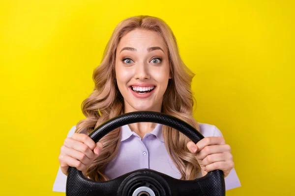 かなり興奮した女性の写真は 車を隔離された黄色の背景に乗って紫色のポロを着用します — ストック写真
