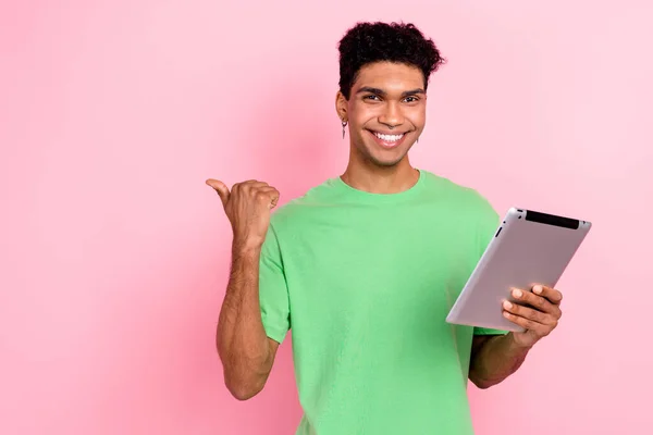 クールな魅力的な男の写真は 現代のデバイスをタイプする緑のTシャツを着用します 親指の空のスペース ピンク色の背景 — ストック写真