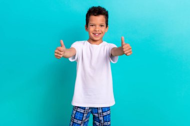 Photo of satisfied friendly boy wear trendy white clothes thumb up cool choice nice quality isolated on cyan color background. clipart