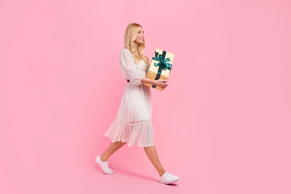 stock image Full body length size photo of young optimistic lady walk guest giftbox present for birthday person isolated over pink color background.