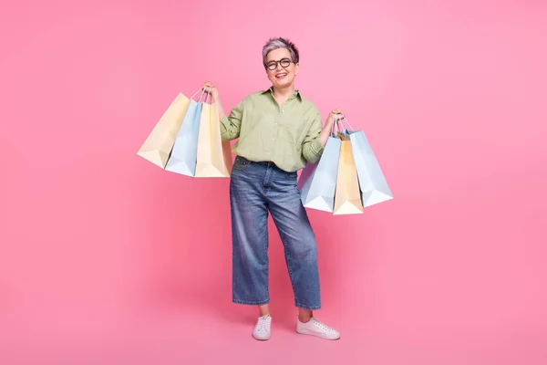 Full body photo of businesswoman shopaholic brand assistant sale proposition advert hold packages isolated on pink color background.