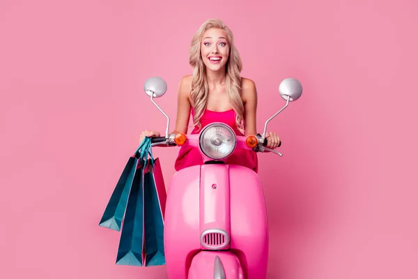 Photo of cheerful excited lady wear sexy dress hurrying delivering bargains riding moped isolated pink color background.
