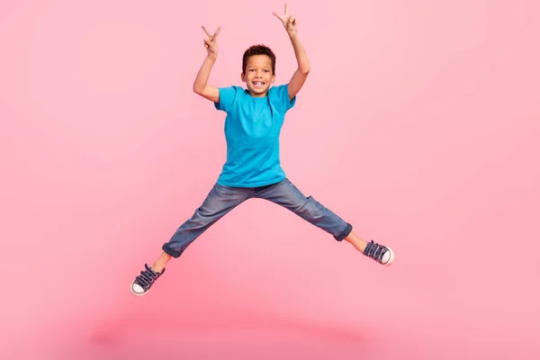 ポジティブな興奮した小さな男の子の完全な長さの写真 ブルーTシャツを着た ハイジャンプ Vサイン隔離されたピンク色の背景を示す — ストック写真