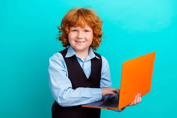 stock image Photo portrait of cute curly ginger boy netbook study remotely dressed stylish school uniform clothes isolated on cyan color background.