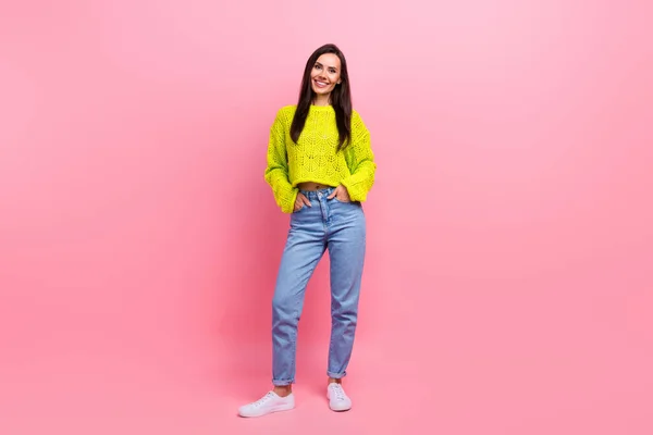 ポジティブな愛らしい少女の完全な長さの写真は 黄色のセーターハンドポケットパンツコレクションの服をピンク色の背景に分離しました — ストック写真