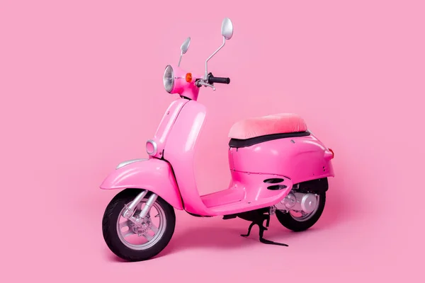 Photo of bright transport for woman comfortable seat italian style scooter isolated on pink color background.