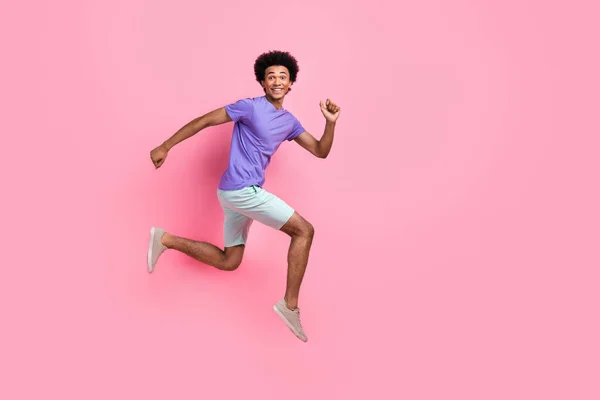 快適な満足した男のフルサイズの写真は ピンク色の背景に隔離された素晴らしい夏の販売に走っているTシャツパンツを着用します — ストック写真
