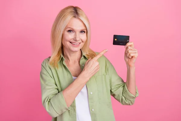 stock image Photo of positive charming retired lady wear trendy clothes recommend pay by plastic card isolated on pink color background.