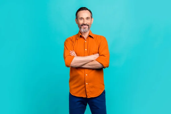 ポジティブな魅力的な男の写真 オレンジ色のシャツの腕を着用 笑顔の孤立したティール色の背景 — ストック写真
