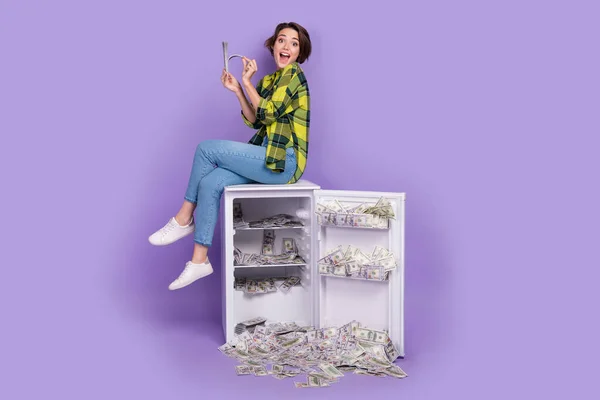 Full body photo of young businesswoman rich person receive salary investor save her money inside fridge isolated on purple color background.