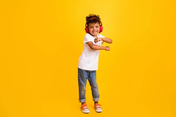 愛らしいかわいい小さな男の子の完全な長さの写真 白いTシャツを着用 リスニングミュージックヘッドフォン 隔離された黄色の背景 — ストック写真
