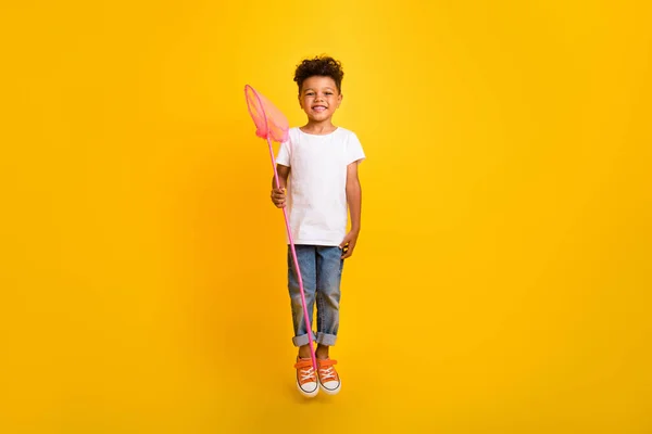 全长照片 迷人可爱的小男孩身穿白色T恤衫 手持勺子跳高孤立的黄色背景 — 图库照片
