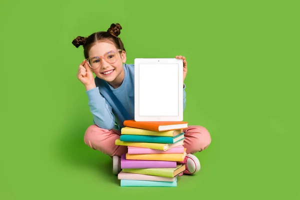 聪明聪明的小女孩身穿蓝色套头衫 手持石碑在绿色背景的书本触摸眼镜上的全身照片 — 图库照片