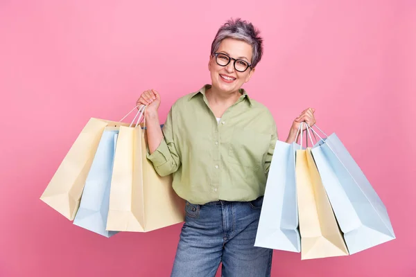 年金受給者のビジネスレディーの写真は パッケージバーゲンショッピングショップブラックフライデーをピンク色の背景に隔離したカーキシャツを着用します — ストック写真