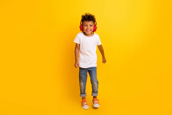 全长照片 可爱时髦的小男孩穿着白色T恤衫跳舞 欣赏着离奇的黄色耳机 — 图库照片